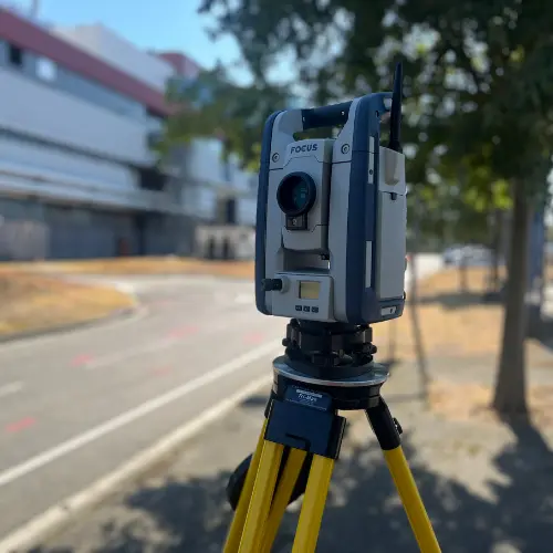 Station Totale Focus pour Levés Topographiques de Précision Station totale Spectra Focus sur trépied jaune lors d'un relevé topographique extérieur par temps ensoleillé.